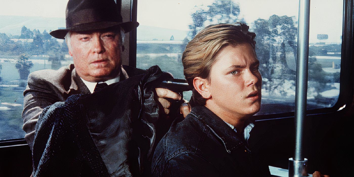 River Phoenix as Jeff Grant being held at gunpoint by Richard Bradford as Konstantin Karpov in Little Nikita