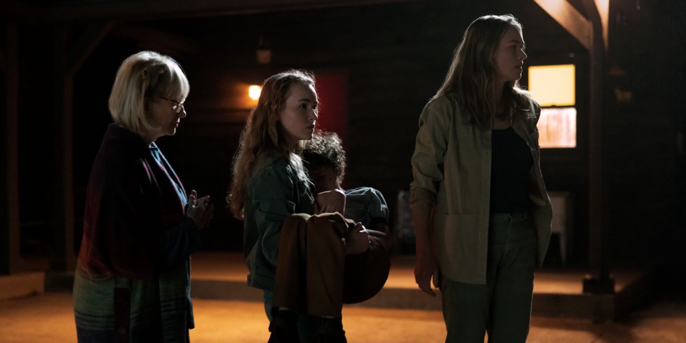 A family stands together looking worried in a barn