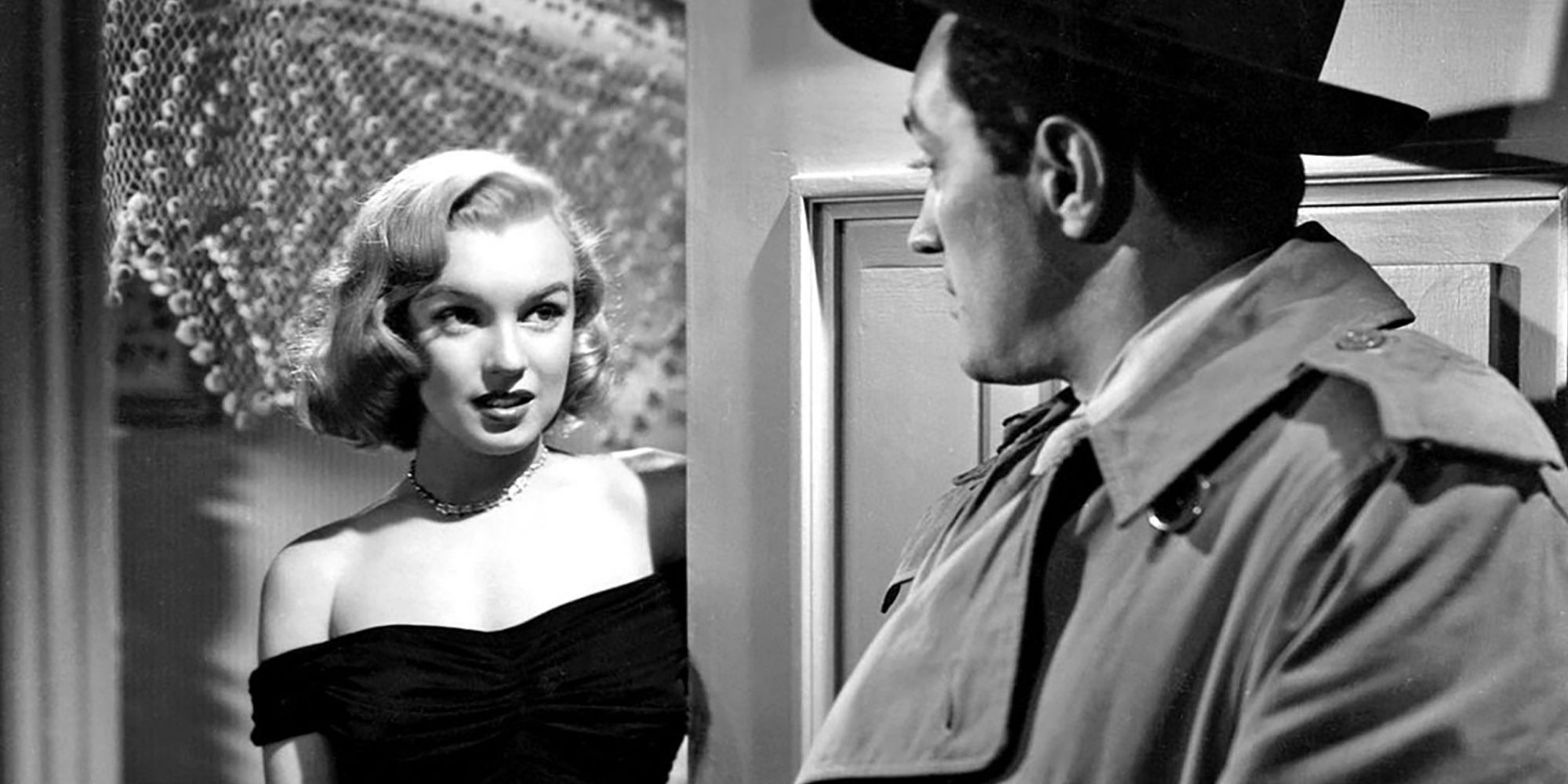 Marilyn Monroe standing in an open doorway looking at Don Haggerty in The Asphalt Jungle (1950)