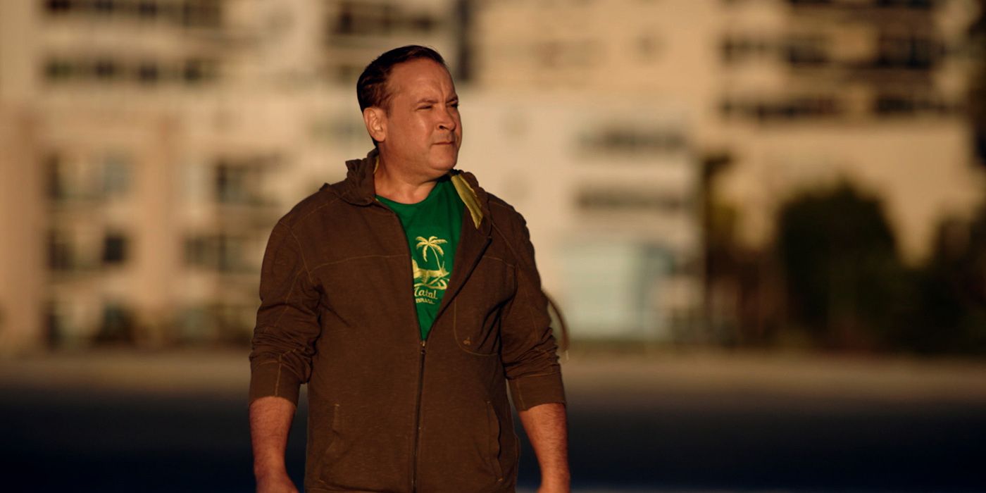 Roy Rosello looking pensive in a hoodie in the street, the background blurred in Menendez + Menudo: Boys Betrayed.