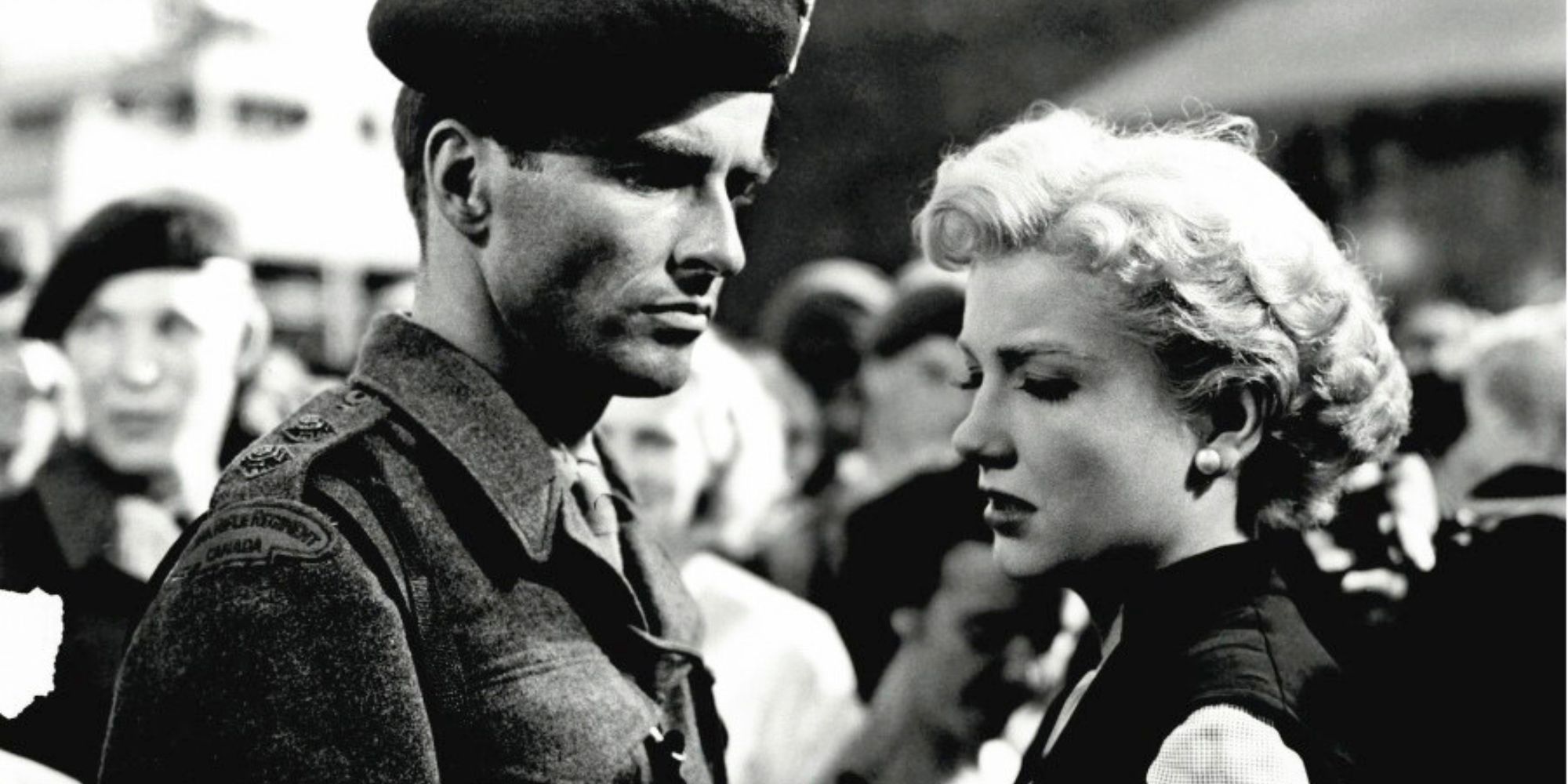 Montgomery Clift as a soldier looks at Anne Baxter in a crowd in I Confess (1953)