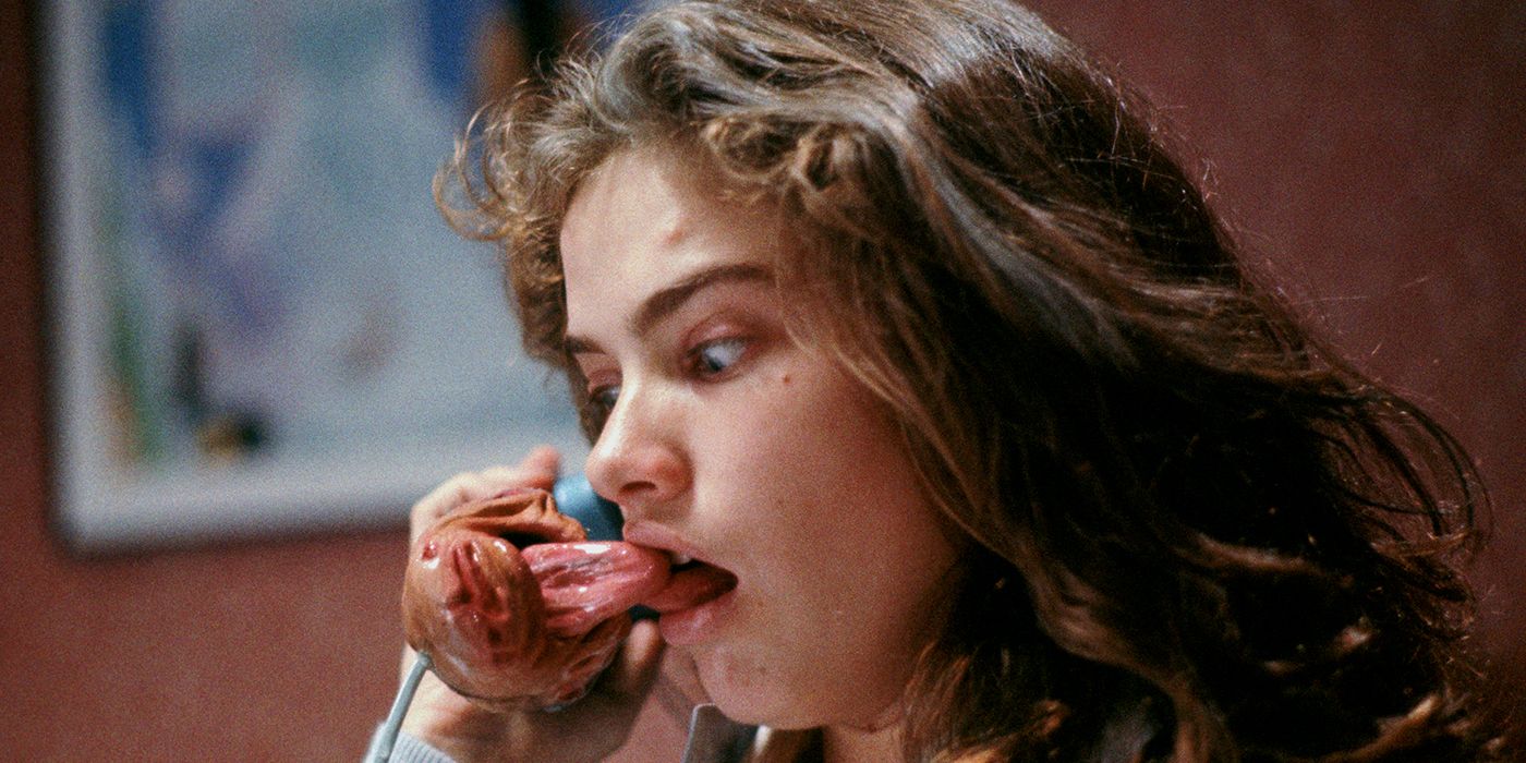 Heather Langenkamp as Nancy, holding a telephone with a tongue protruding from it in A Nightmare on Elm Street