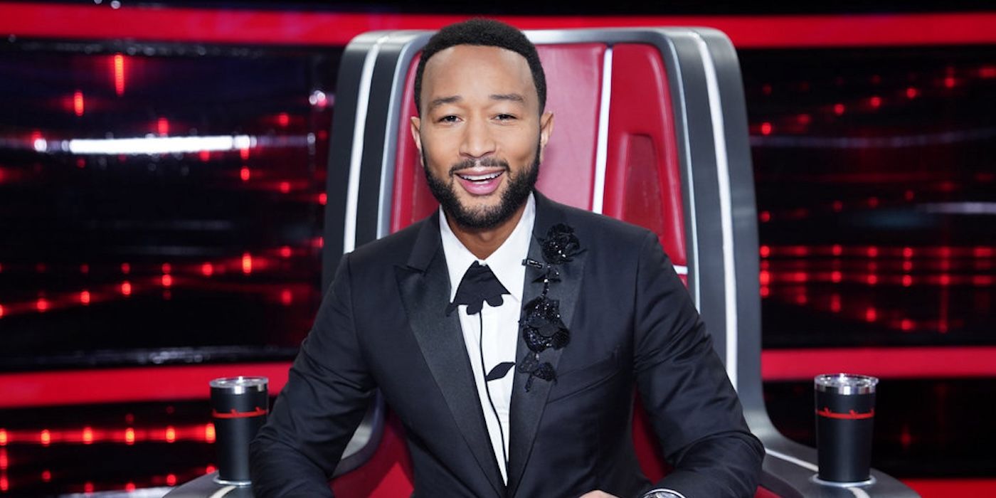 John Legend wears a tuxedo and sits in a judge's chair on The Voice.