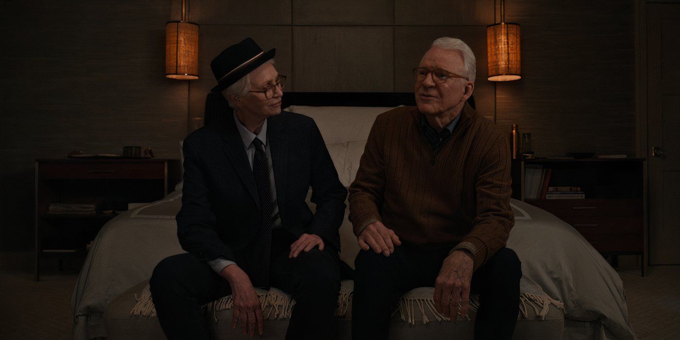 Sazz (Jane Lynch) sits with Charles (Steve Martin) on the edge of a bed