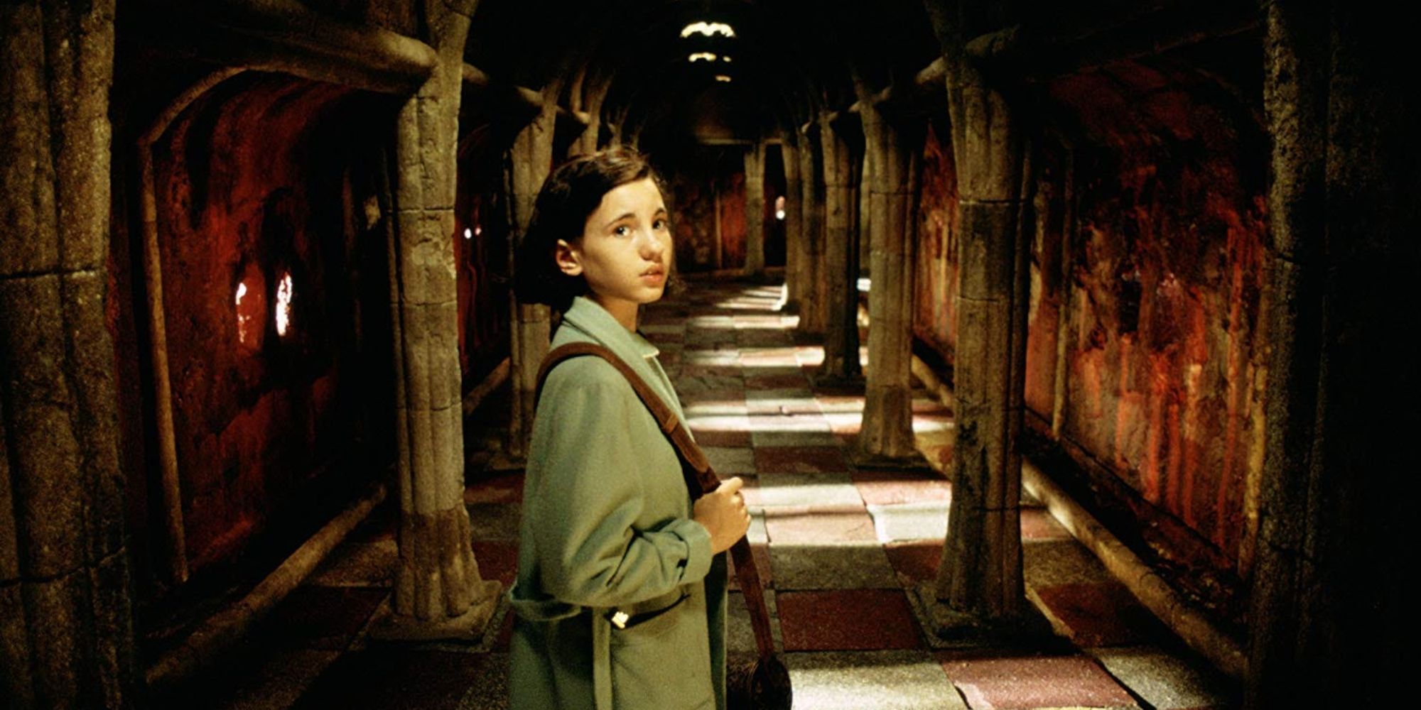 Ofelia looking scared at the foot of a hallway in Pan's Labyrinth