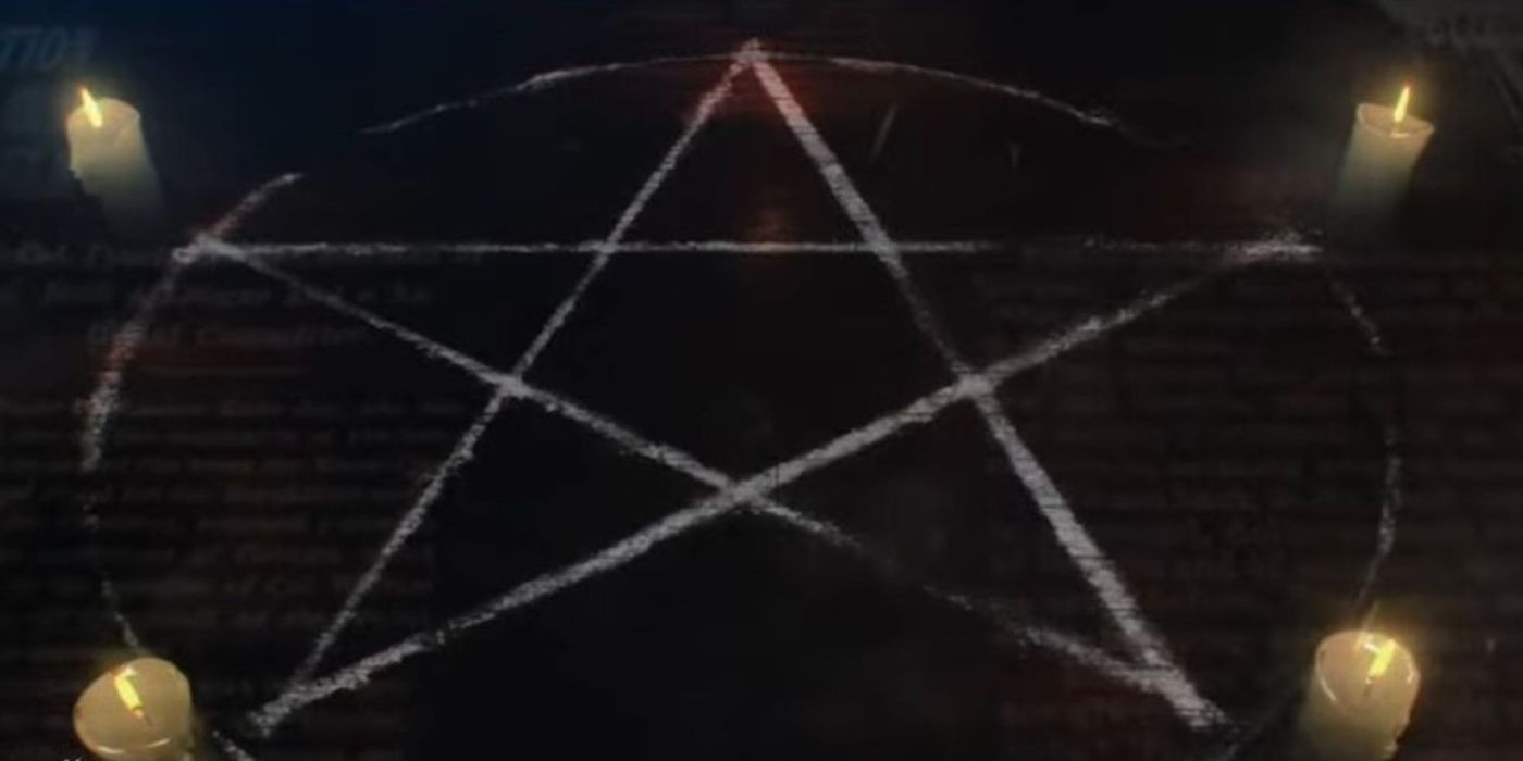 An image of a pentagram drawn on the ground with lit candles at each point