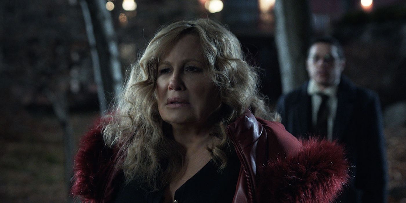 Jennifer Coolidge stands in the woods in Riff Raff. 