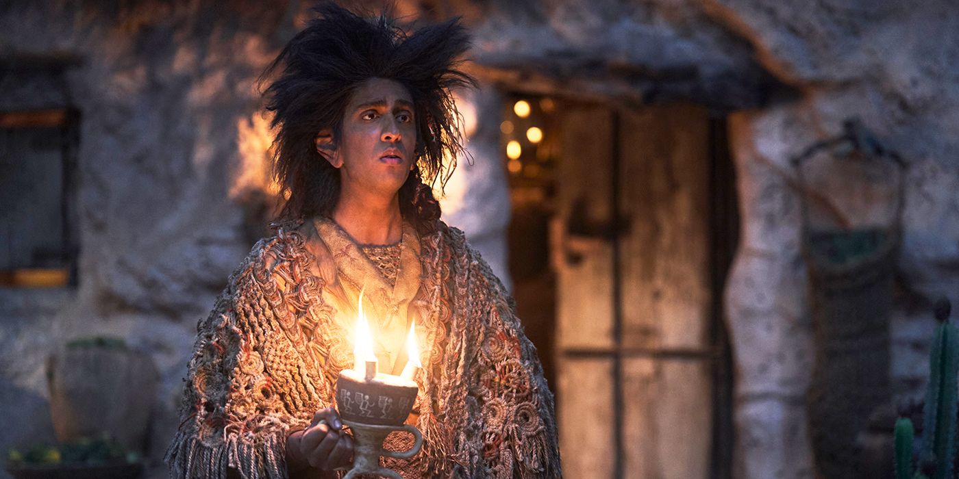 Gavi Singh Chera as Merrimac holding candles at night and looking sadly into the distance in Rings of Power