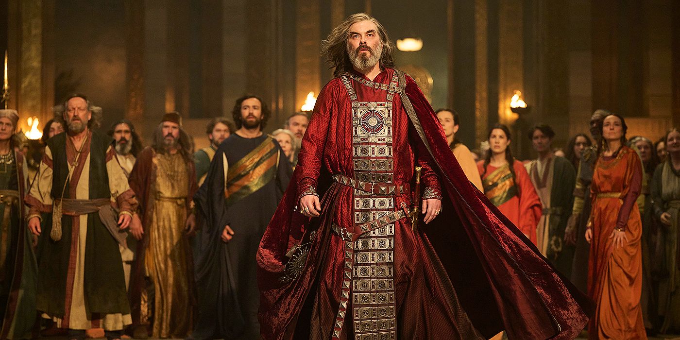 Pharazôn (Trystan Gravelle) standing in front of a crowd in a red robe in The Rings of Power