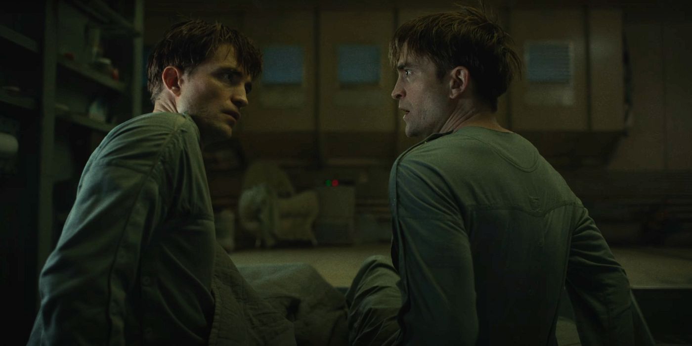 Robert Pattinson as two Mickey clones lying on a bed looking shocked to see each other.