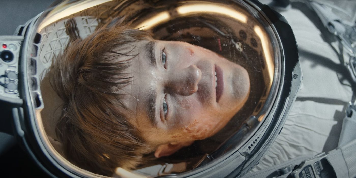 A dead Robert Pattinson as Mickey in his space suit with his face scarred.