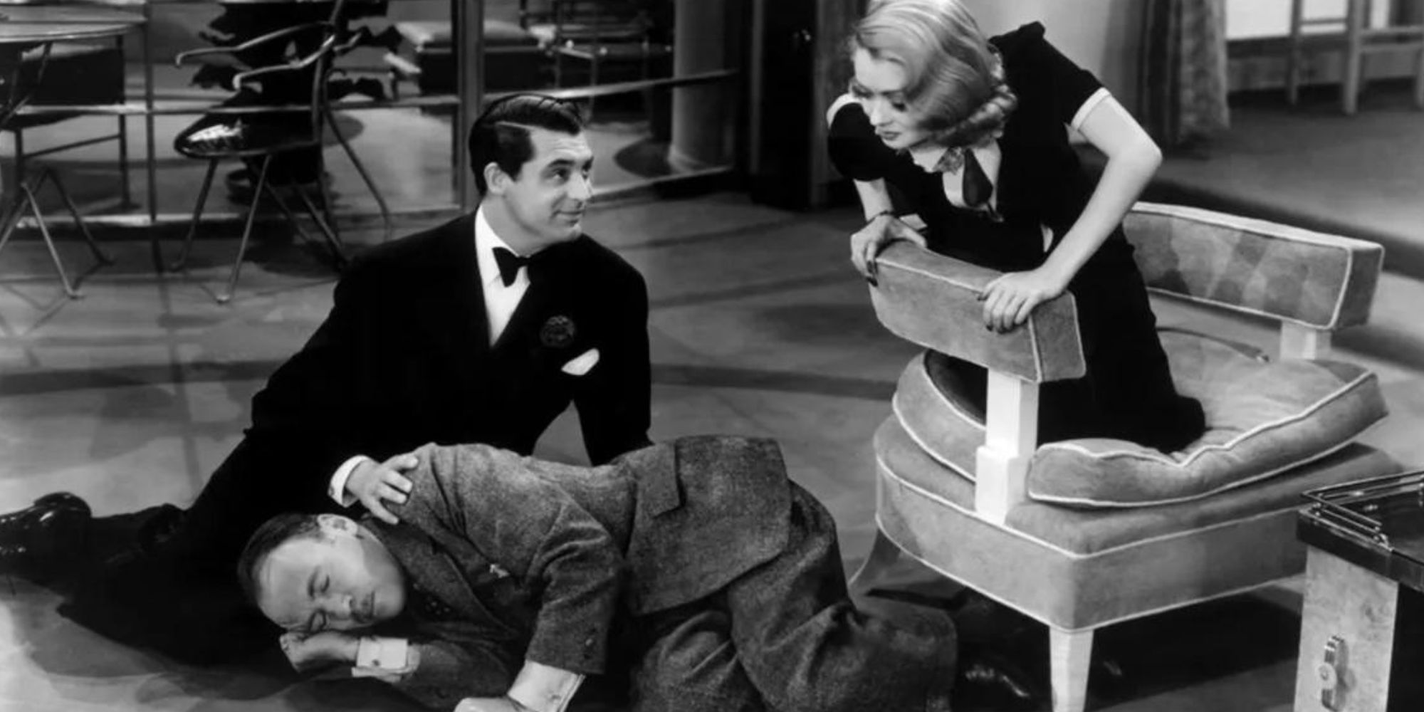 Roland Young lying on the floor asleep with Cary Grant sitting next to him and Constance Bennett kneeling on a chair looking over at him in Topper (1937)
