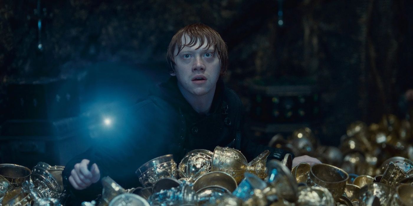 Ron Weasley hold his lit wand amidst a pile of treasure in 'Harry Potter and the Deathly Hallows: Part 2' 