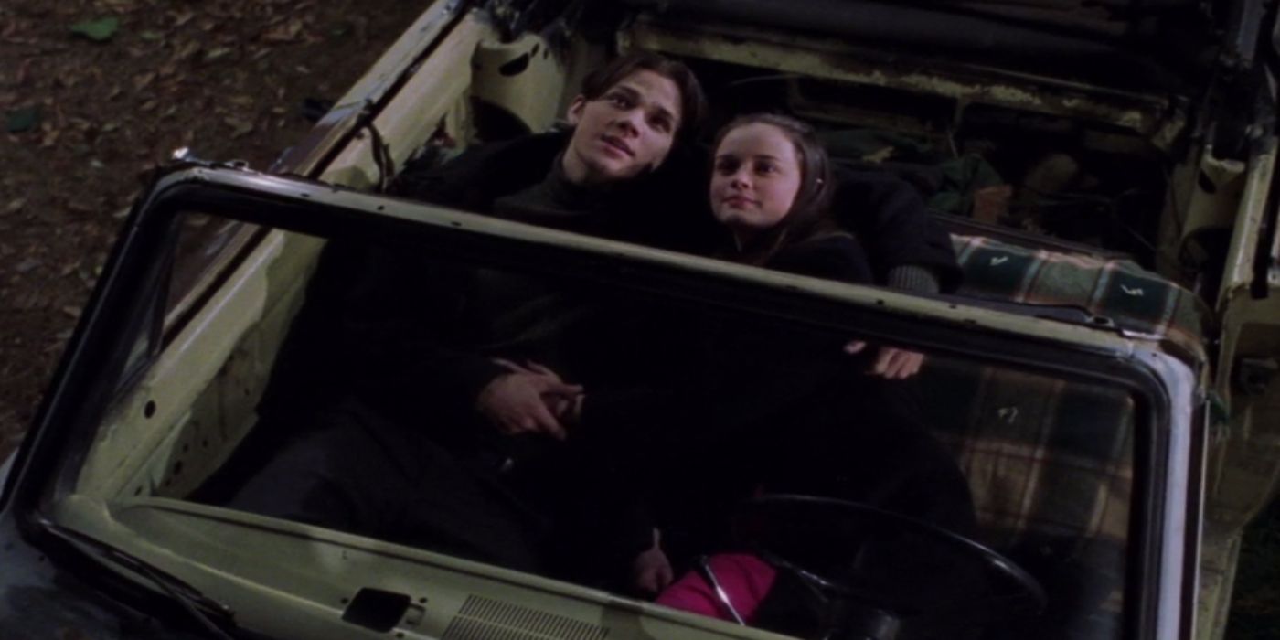 Rory and Dean laying in a car on their anniversary looking at the stars in Gilmore Girls.