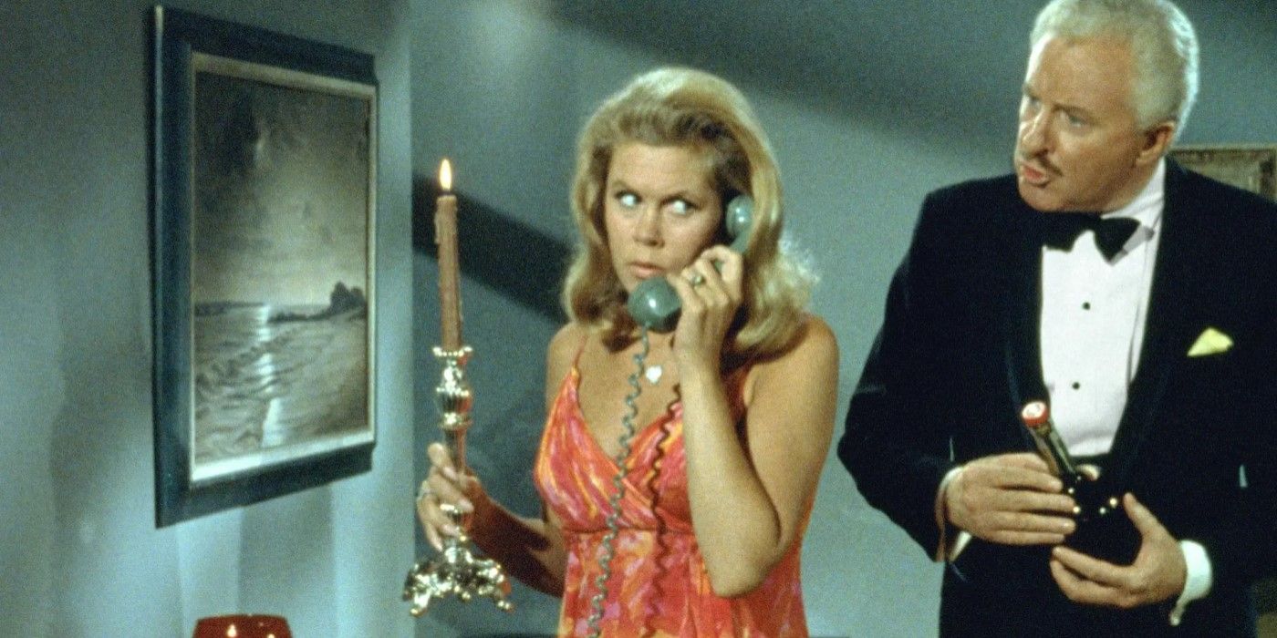 Samantha (Elizabeth Montgomery) holds a candlestick while on the phone, with Larry Tate (David White) standing behind her in 'Bewitched' episode "Sisters at Heart"