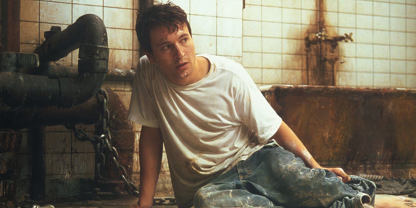 Adam, played by actor Leigh Whannell, on the floor looking confused in Saw