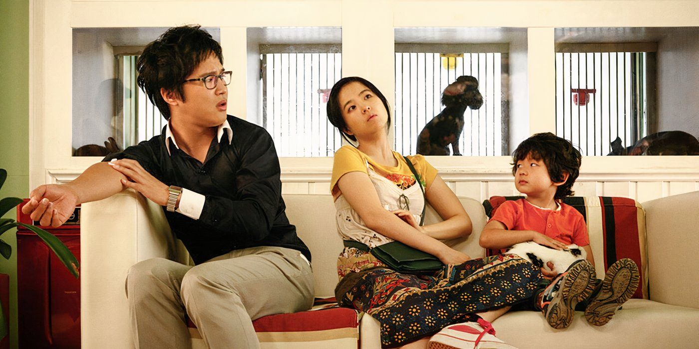 A man, woman, and small child sit on a sofa and contemplate a situation in Scandal Makers.