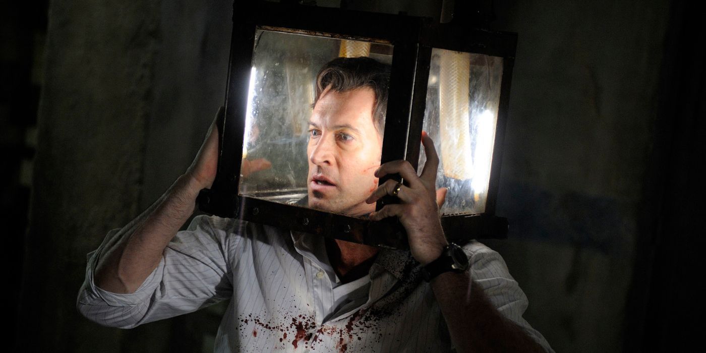 Scott Patterson interpreta al Agente Stram, cuya cabeza está atrapada en una caja de cristal en Saw 5.