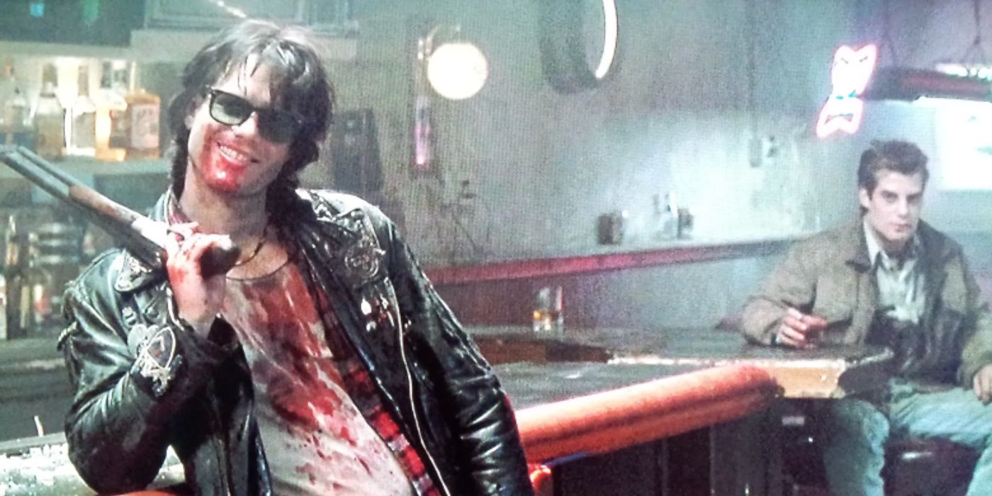 Bill Paxton como Severen, con una camisa ensangrentada y una pistola en un bar en Near Dark.