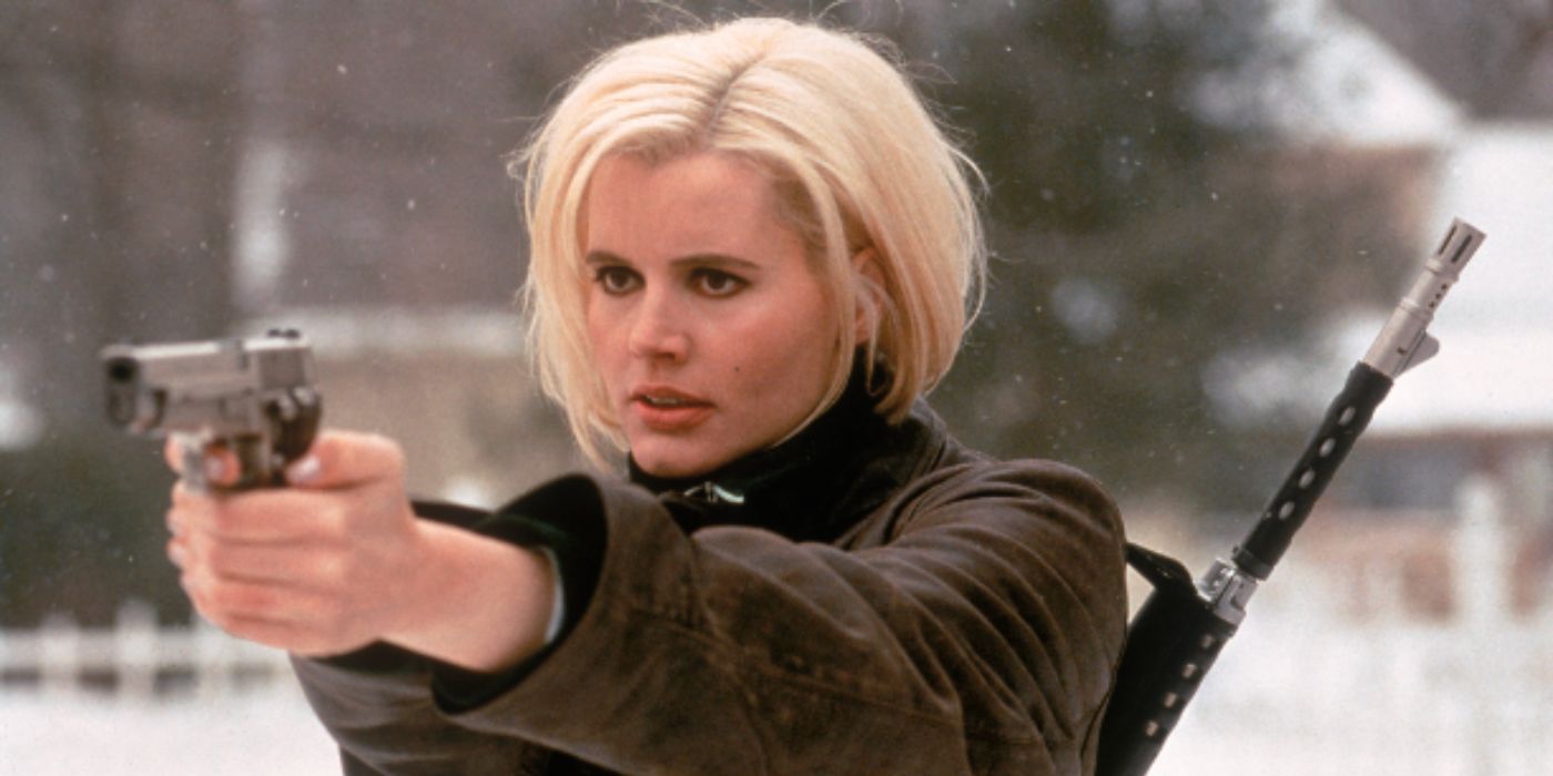 Geena Davis as Samantha with platinum blonde hair pointing a gun outside in the snow in 'The Long Kiss Goodnight'