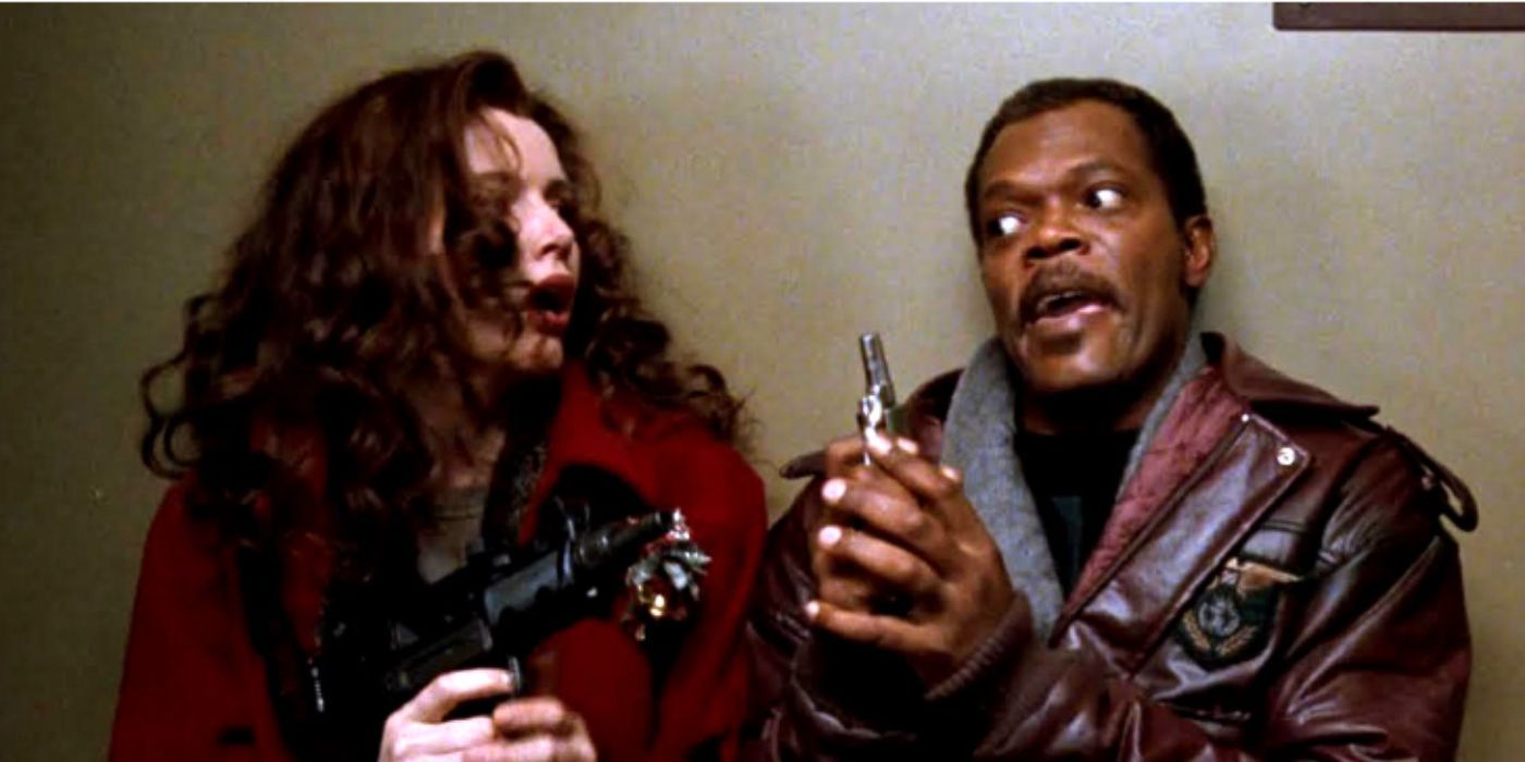 Geena Davis and Samuel L Jackson as Samantha and Hitch holding guns standing in a hallway in &lsquo;The Long Kiss Goodnight&rsquo;