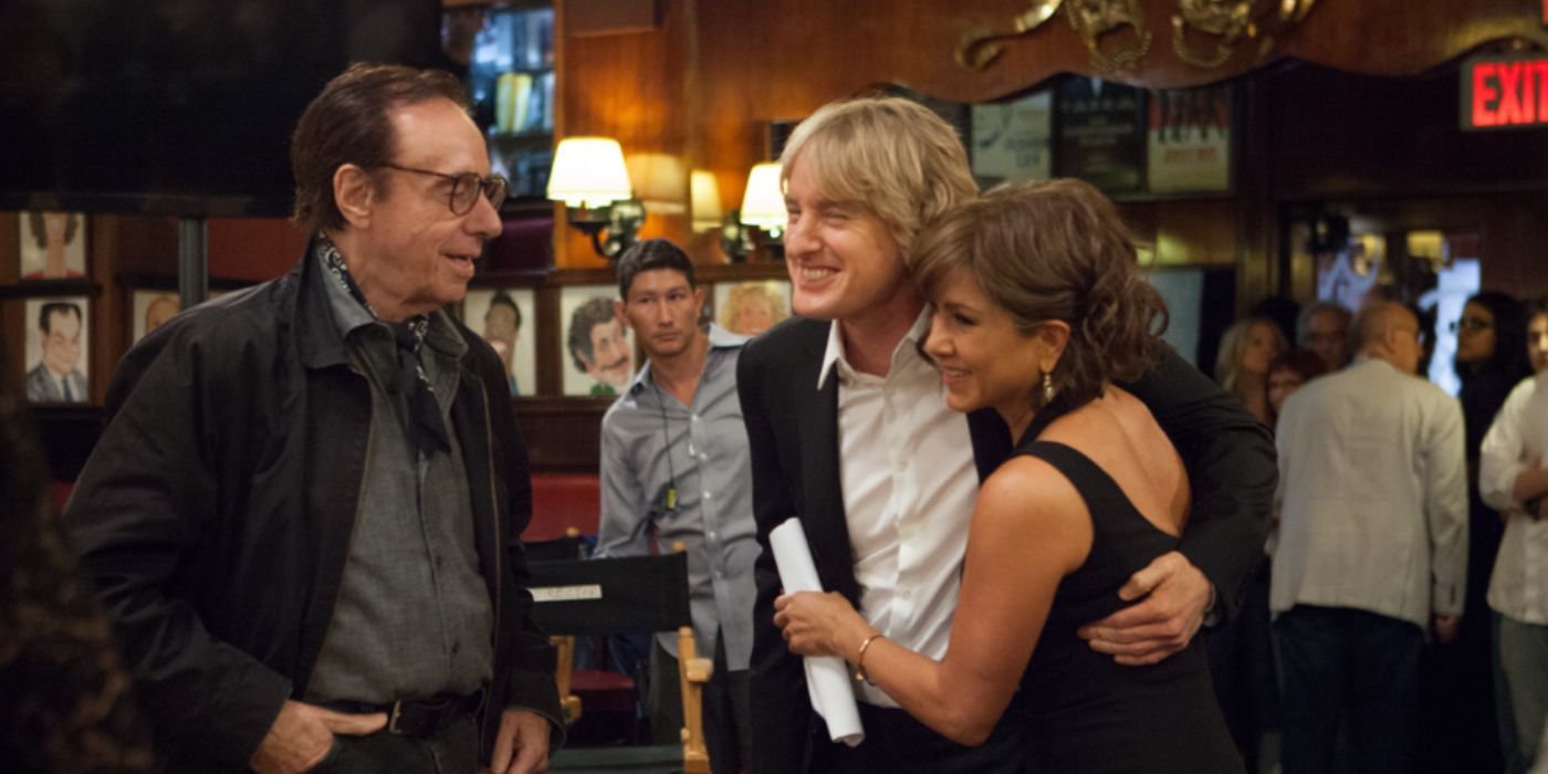 Peter Bognanovich, Owen Wilson, Jennifer Aniston in a bar smiling on the set of 'She's Funny that Way'