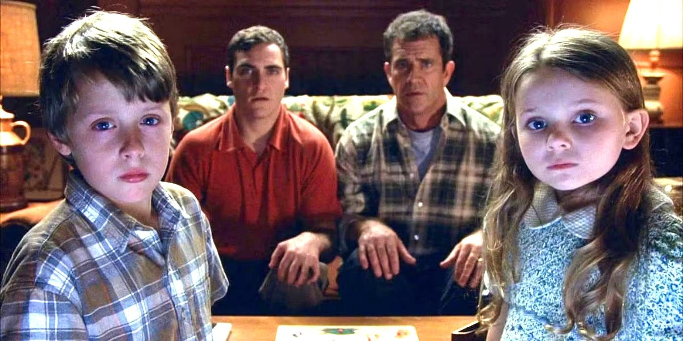 The cast of Signs sit on a couch and gather near a TV screen looking perplexed and fearful in Signs.