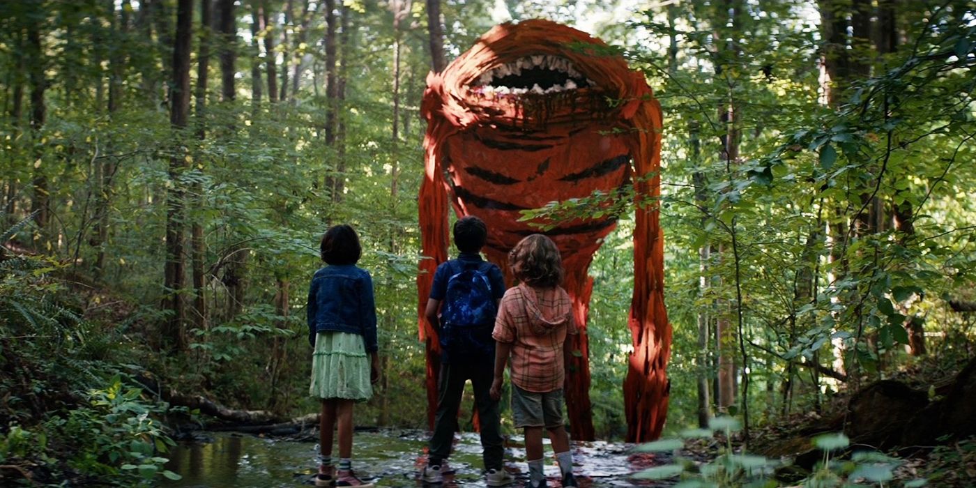 Children in a forest looking up at a strange red monster with a large toothy mouth