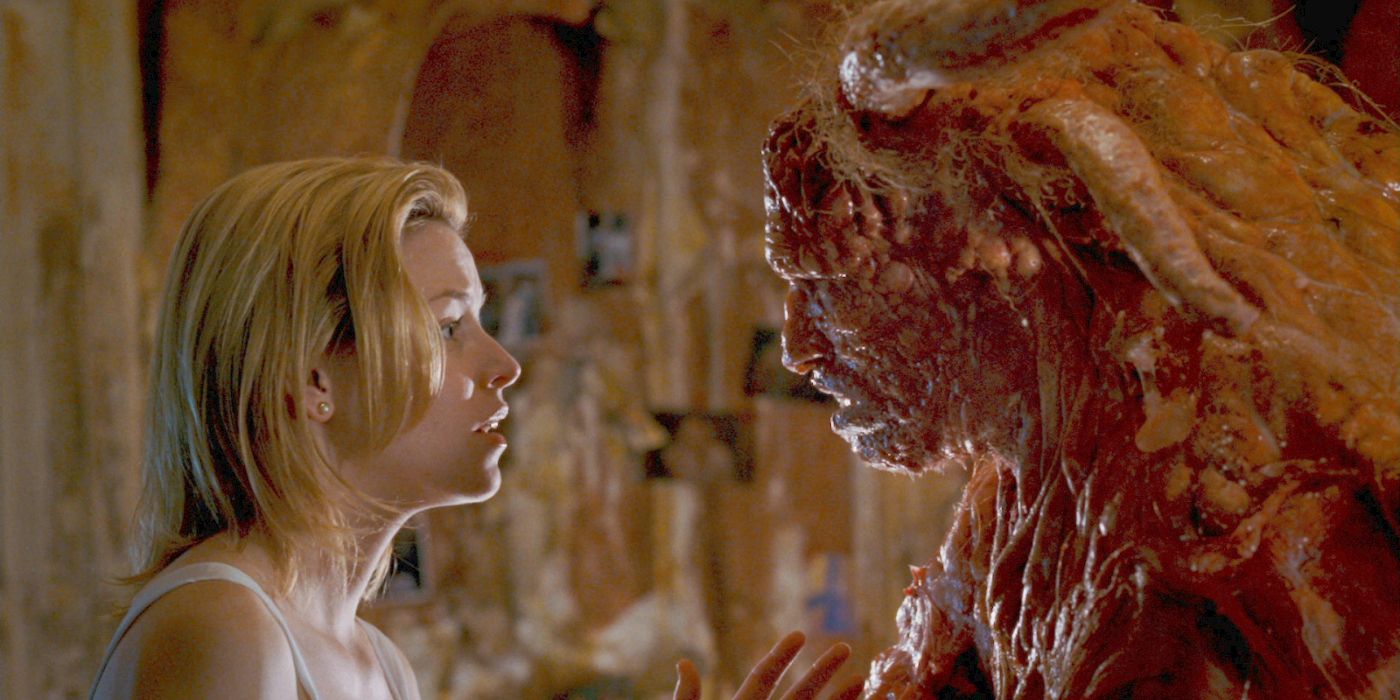 Starla (Elizabeth Banks) in profile staring back at Grant Grant (Michael Rooker) in full alien form in Slither