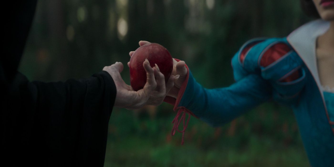 A closeup of the Evil Witch handing Snow White an apple in the live-action remake.