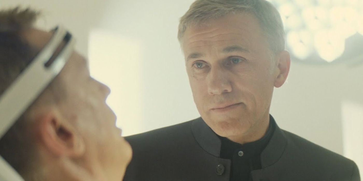 Blofeld (Christoph Waltz) stands over a restrained James Bond (Daniel Craig), looking him in the eye in 'Spectre' (2015).