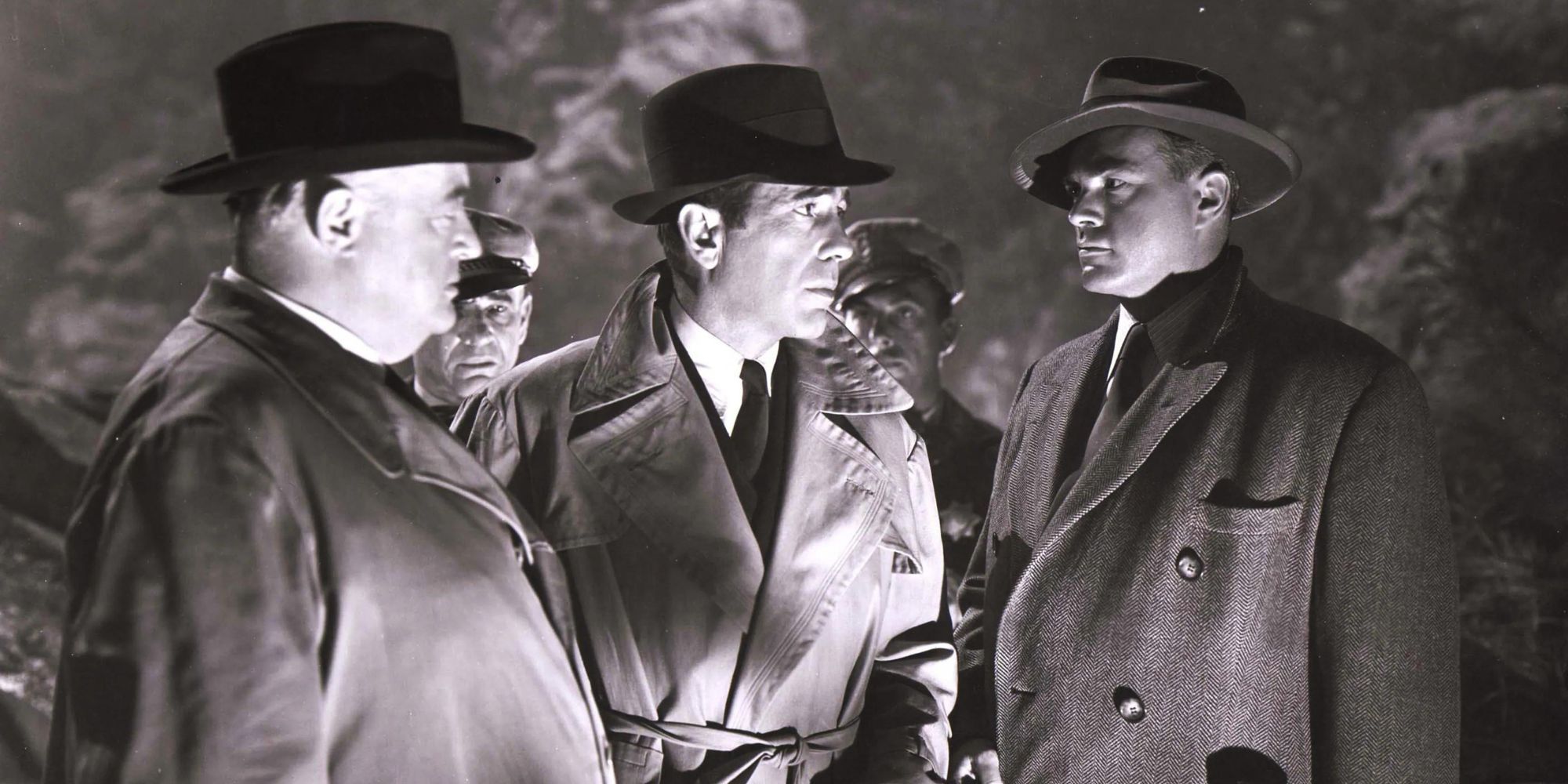 Three men talking while standing next to each other outside in the dark in Conflict