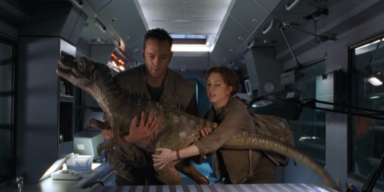 Nick (Vince Vaughn) and Sarah (Julianne Moore) hold onto a baby T. rex in 'The Lost World: Jurassic Park'.