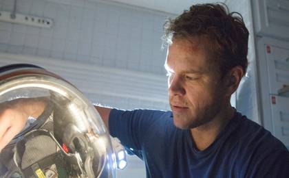 Matt Damon as Mark Watney fixing his helmet in The Martian