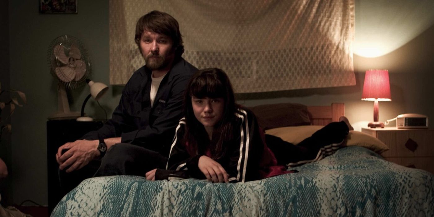 Joel Edgerton and Hanna Mangan Lawrence sitting on a bed and staring at the camera in The Square (2008)