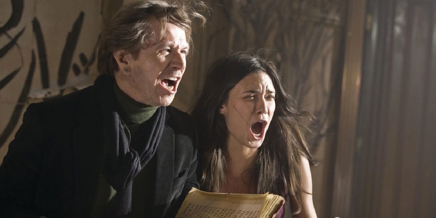 Gary Oldman as Rabbi Sendak and Odette Annable as Casey Beldon shouting words from an ancient scripture in The Unborn