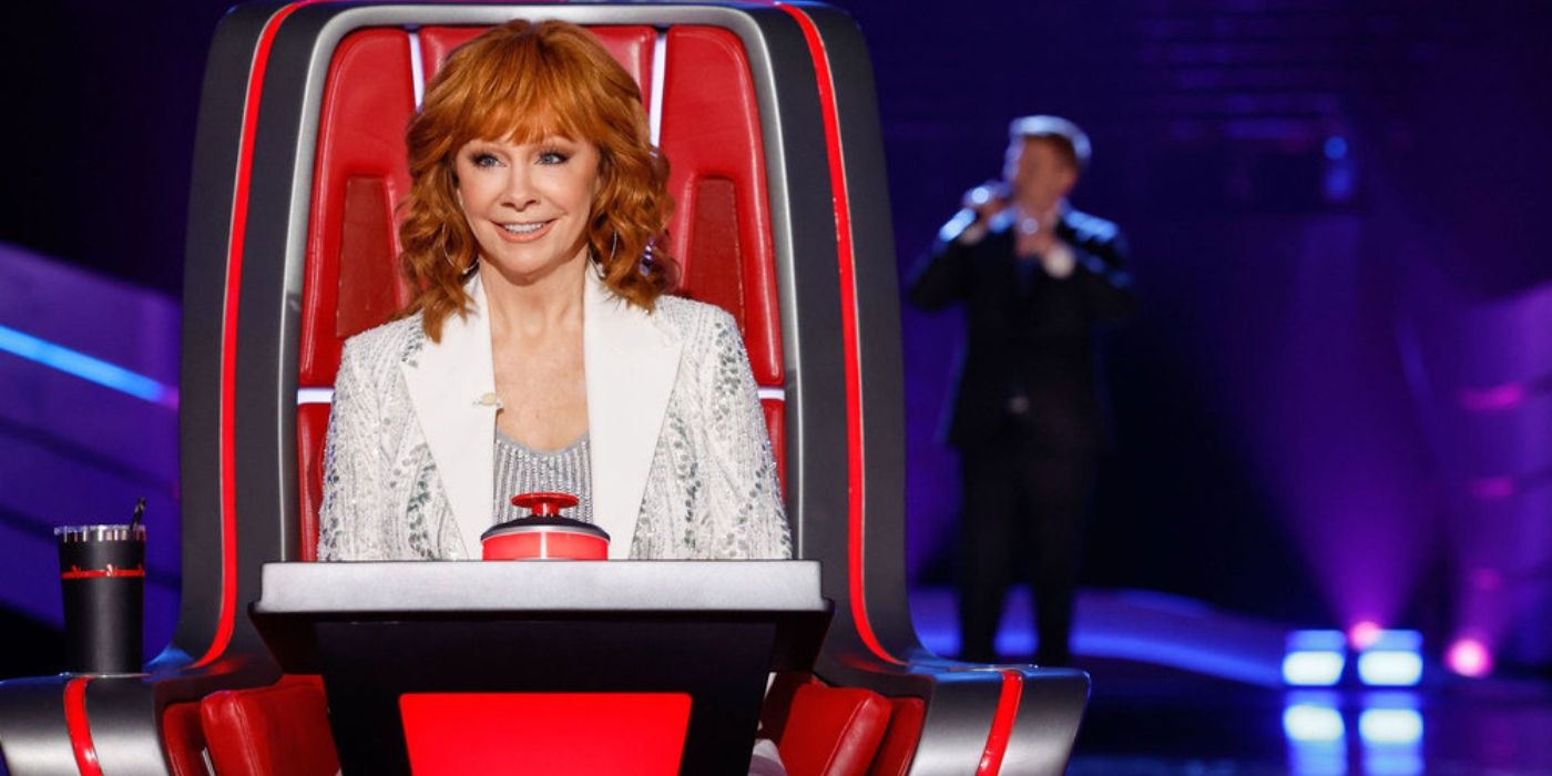 Reba McEntire smiles as she listens to a singer on 'The Voice' Season 26.