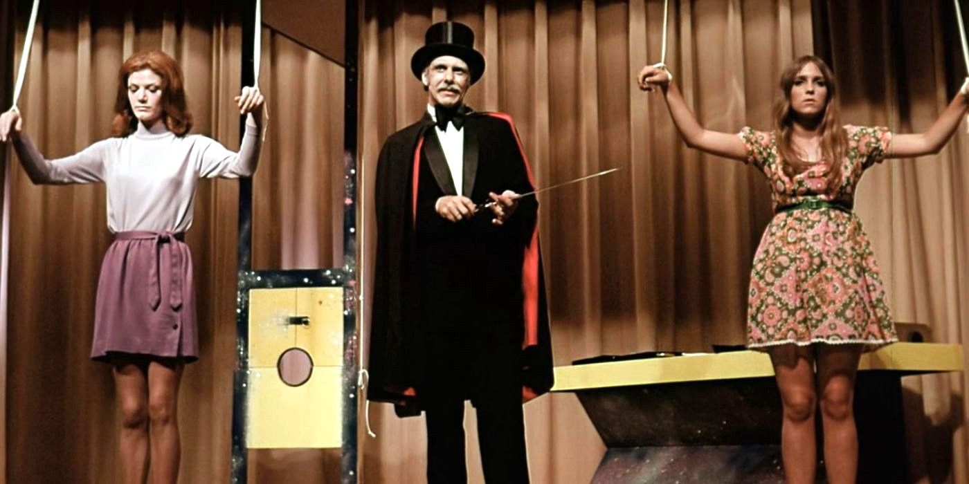 A man dressed as a magician with two women on either side with their hands tied in The Wizard of Gore 1970.