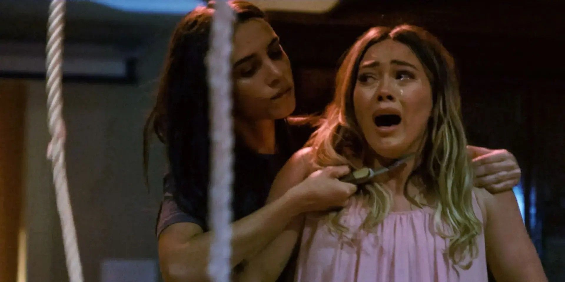 A woman holding a pocket knife up to another woman's throat in 'The Haunting of Sharon Tate' (2019)