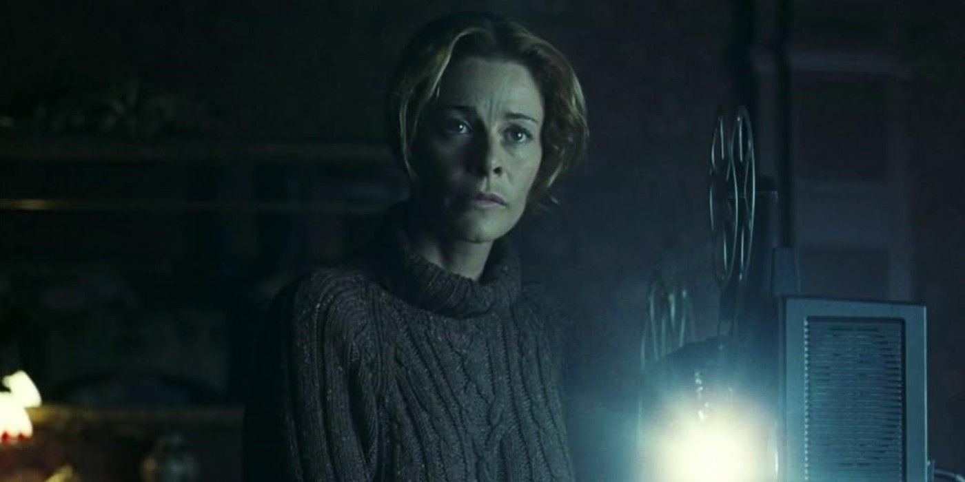 Belen Rueda as Laura standing next to a running projector in The Orphanage.