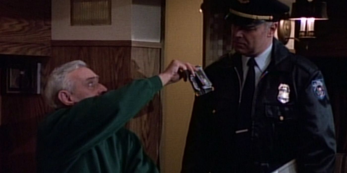 Martin Crane shows a photo of Eddie under the Space Needle and his police badge to a Canadian patrol officer.