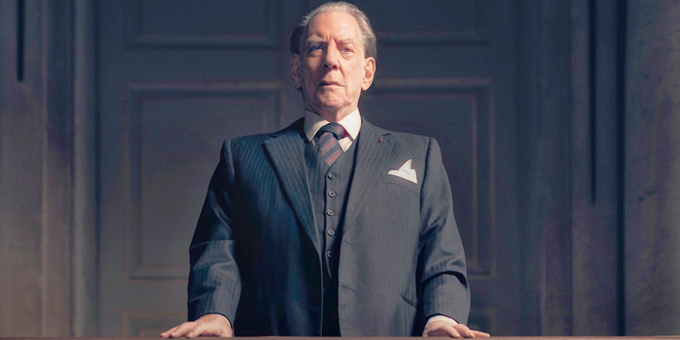 Donald Sutherland as John Paul Getty standing on a balcony wearing a grey suit in 'Trust'