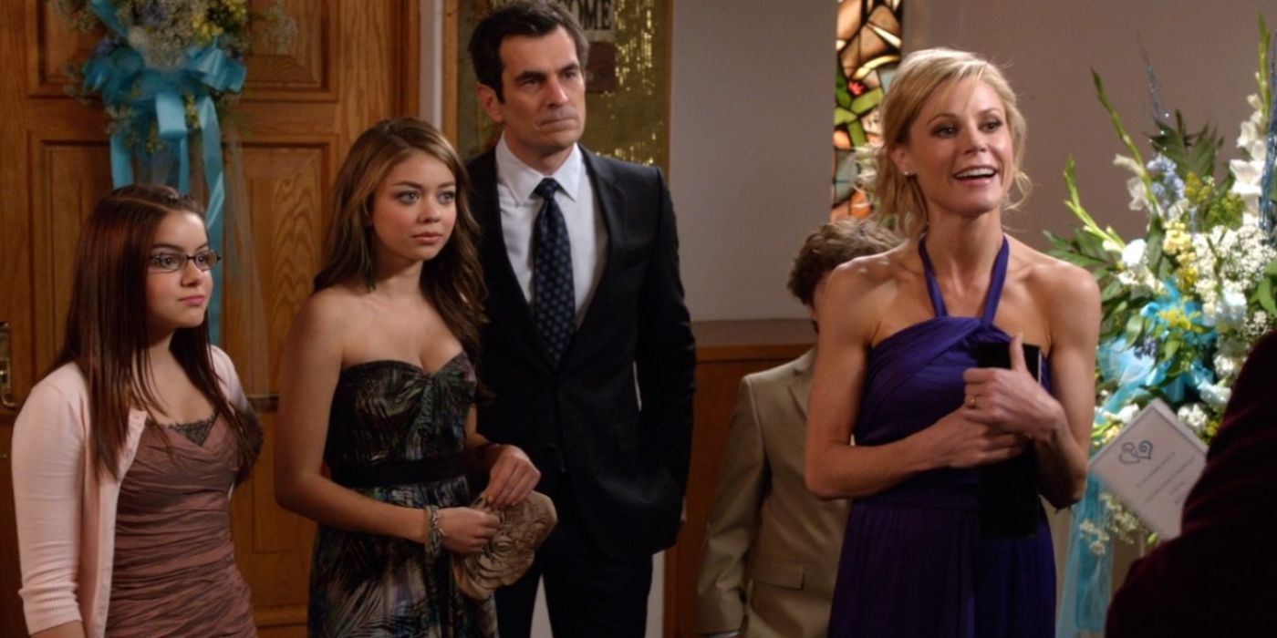 Claire (Julie Bowen), Phil (Ty Burrell), Hayley (Sarah Hyland) and Alex Dunphy (Ariel Winters) standing in a church in Modern Family. 