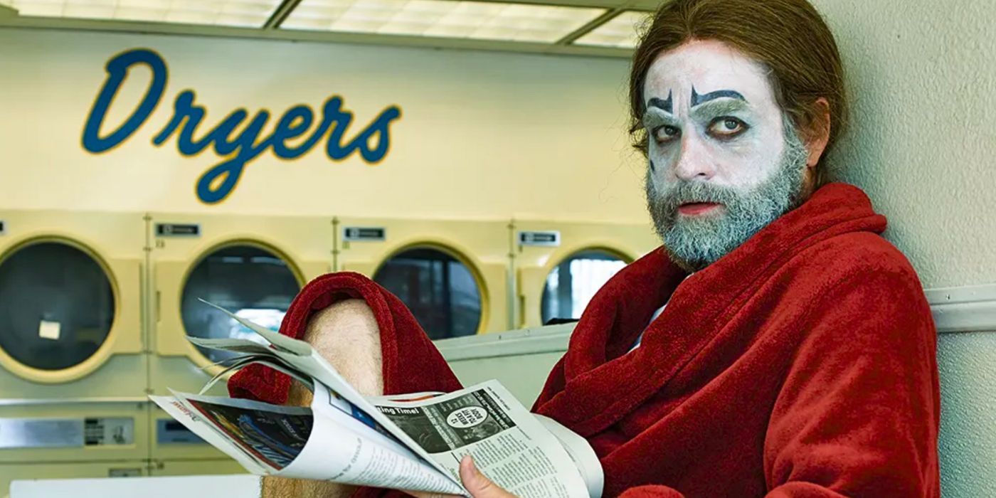 Zach Galifianakis reads a newspaper while wearing clown makeup and a red robe at a laundromat in the FX series Baskets