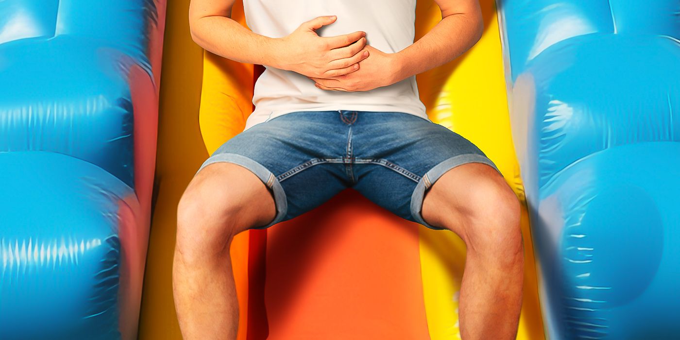 A Man going down a slide and holding his stomach because he has to poop