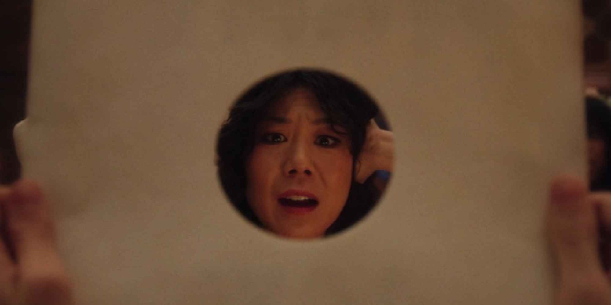 Alice Wu-Gulliver seen through the hole of a record sleeve in &lsquo;Agatha All Along&rsquo;
