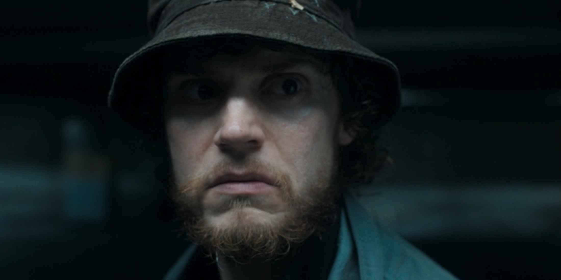 Ralph Bohner (Evan Peters) in a dark parking garage wearing a bucket hat in Agatha All Along