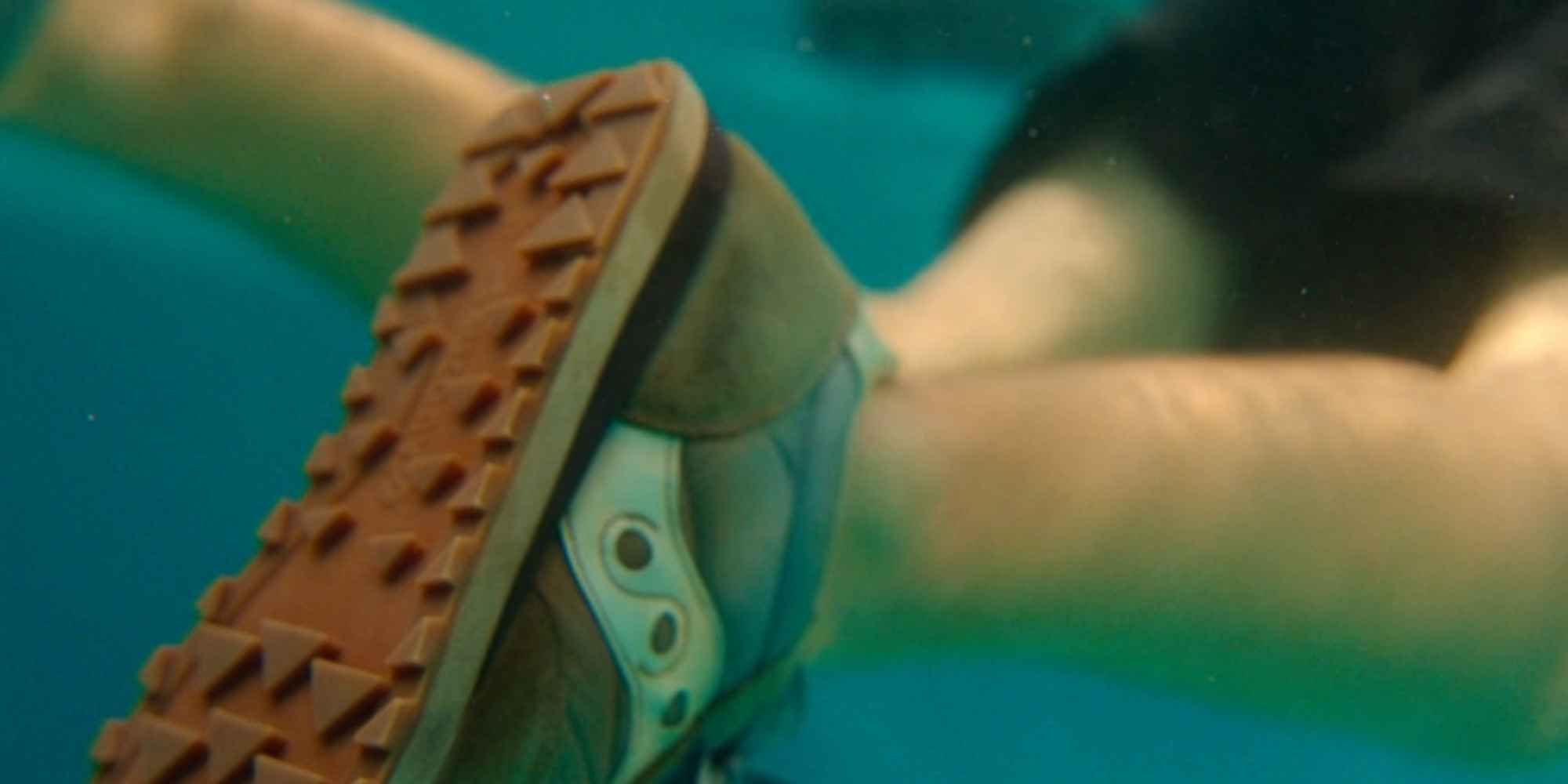 A boy's legs seen floating in water, with blue and white shoes in 'Agatha All Along'