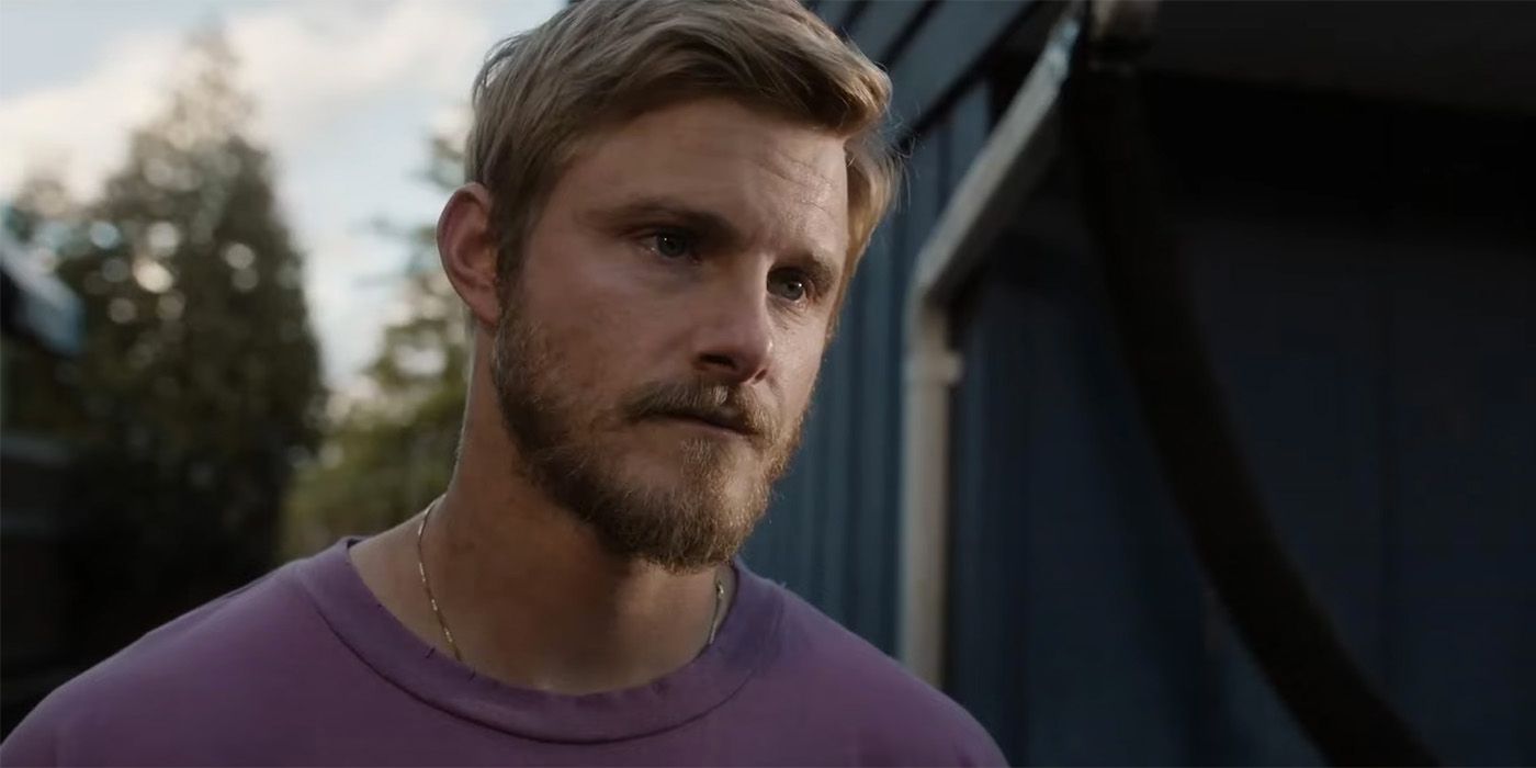 Alexander Ludwig standing outside wearing a purple shirt in Earth Abides