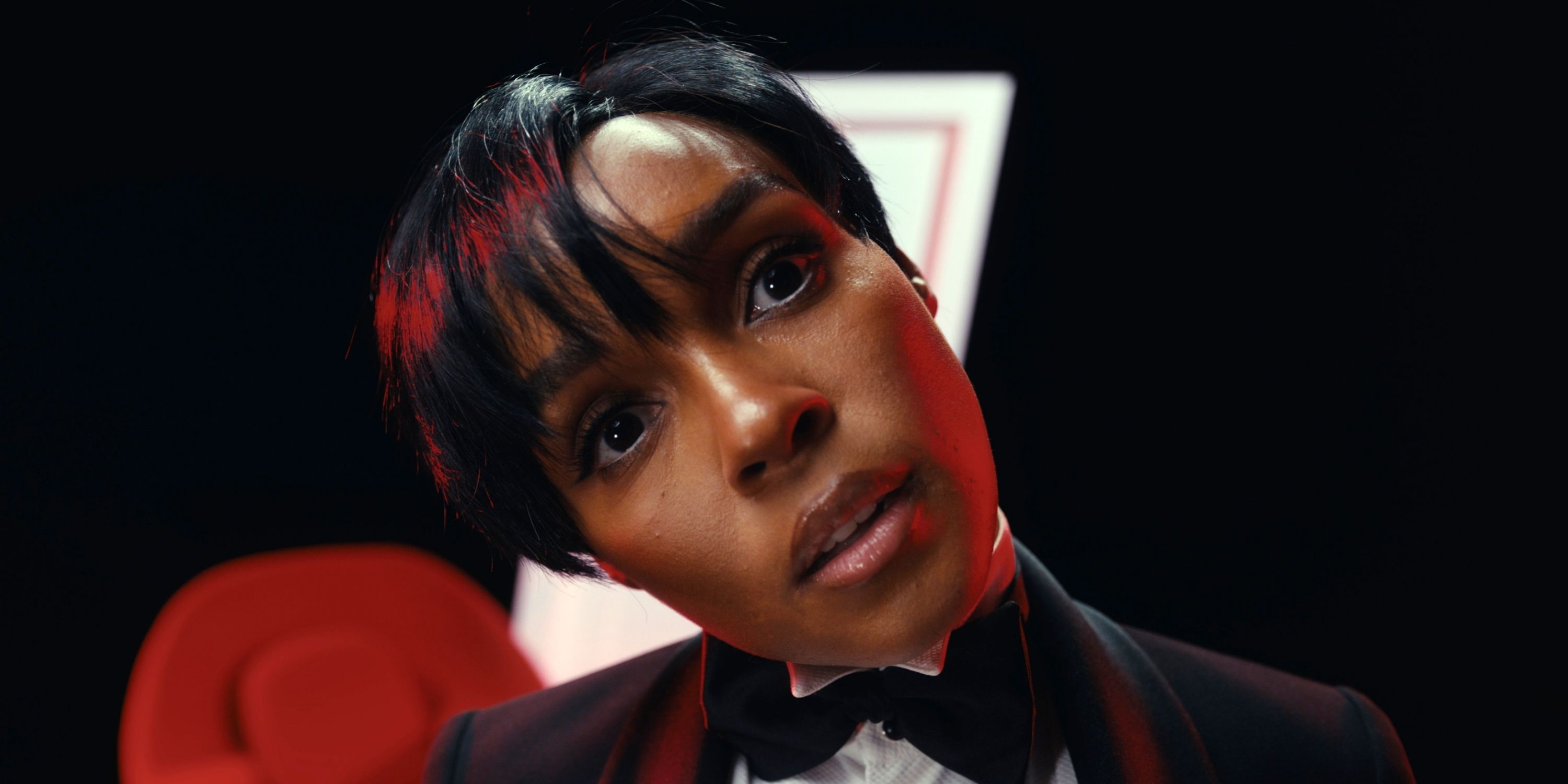 Janelle Monáe in a tuxedo in close-up with her head tilted to the right as host of AMC's FearFest